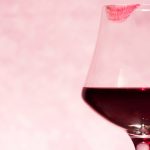 A wine glass with a lipstick stain.