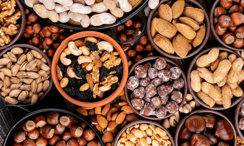 Set of walnuts, raisins, pecan, pistachios, almond, peanut, cashew, pine nuts and assorted nuts and dried fruits in different bowls.
