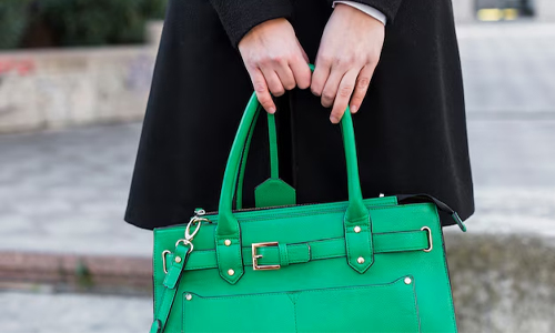  woman holding a green handbag