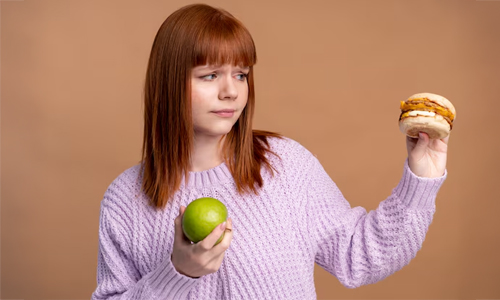 A girl with a fruit and a burger
